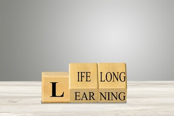 Lifelong learning symbol. Turned wooden cubes for concept words. Business, educational and lifelong...