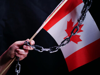 Canadian flag in chains on dark background
