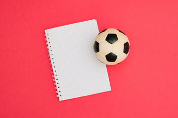 Football and soccer A6 notebook wire binding mock up blank template design idea. Black and white soccer ball mockup against pastel pink background. Copy space templates designs for message layout.