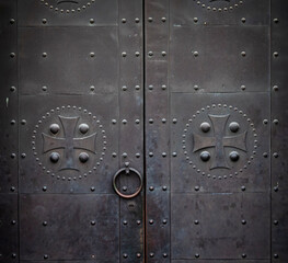 old metal door with knocker and christian symbols