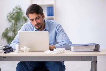 Young male employee suffering at workplace