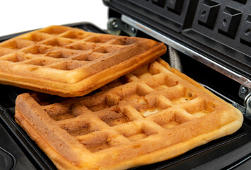 New modern waffle maker with waffles isolated on white. homemade baking
