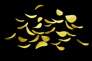 Crispy potato chips flying in the air. On an black background. Fast food.