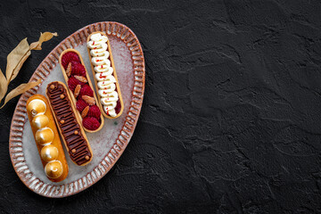 Sweet bakery eclairs with creamy decor, top view