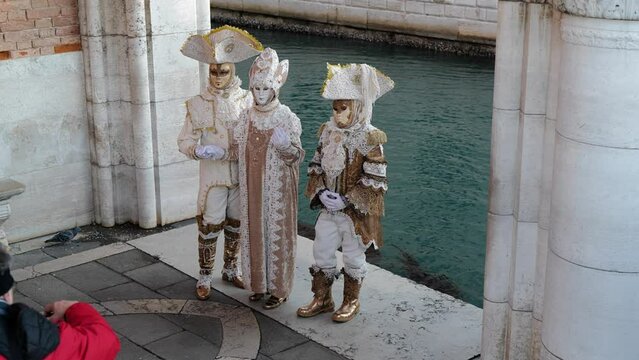 Venice, Italy - February 2022 - carnival masks are photographed with tourists in San Marco square