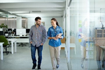 Ill walk you out. Shot of two colleagues talking while walking in the office.