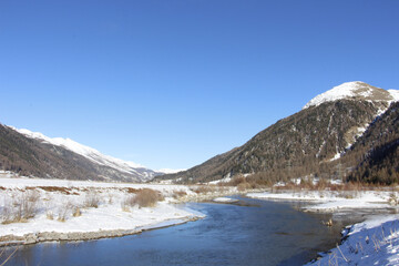 Scenic view of a river surrounded by rocky hills in a rural area in winter