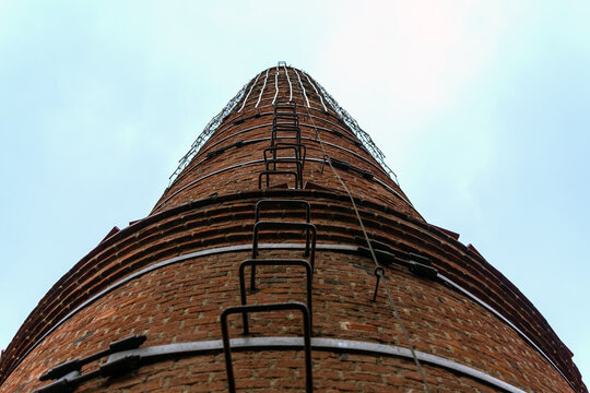 Industrial pipe made of bricks with a ladder in the form of staples driven into the pipe