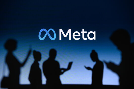NEW YORK, USA, 1. MARCH 2022: Meta or Metaverse logo on big screen, Facebook company, Meta Platforms. business and employment-oriented online service Group of business people chat on phone and laptop