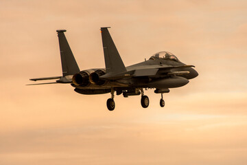 Avión de combate F-15 aterrizando al anochecer