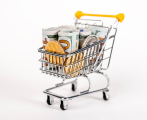 Supermarket trolley with rolled dollar notes and coins. Income and money spent by shopping concept. High quality photo