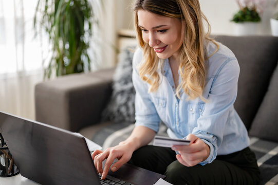 A Young Woman Using A Credit Card At Home To Make A Purchase Or Payment Over The Internet