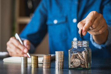businessman with a coin in a glass Along with pressing the calculator and write down savings for the future after retirement, ideas for saving money for the future and life after retirement