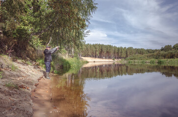 Obraz na płótnie Canvas Fisherman on the bank of a beautiful river.