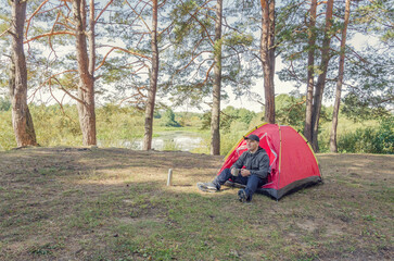 Naklejka na ściany i meble Man camping in the forest.