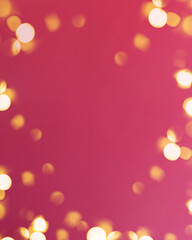 Christmas bright gold colors bokeh different sizes around the frame on vibrant pink blurred background. Holiday template and shiny greeting concept with copy space