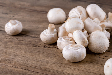 Fototapeta na wymiar Fresh raw organic champignons heap on a wooden table.