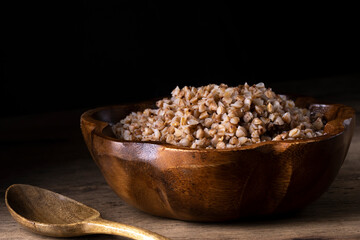 buckwheat in a wooden plate on a wooden background