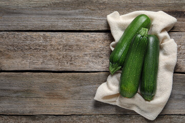 Raw ripe zucchinis on wooden table, flat lay. Space for text