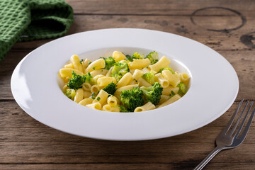 pasta with broccoli on a white plate and wooden table