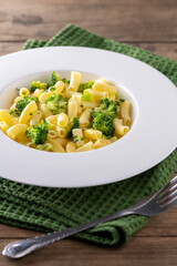 pasta with broccoli on a white plate and wooden table