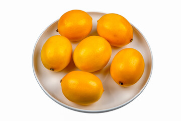 Lemons in round plate on white background