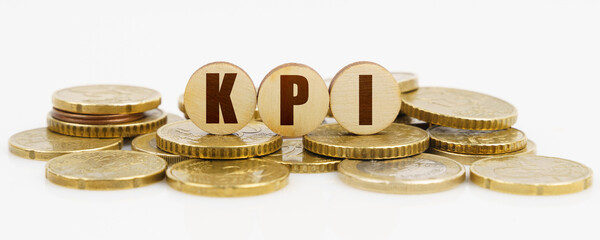 On a white surface lie coins and circles with the inscription - KPI