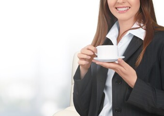 Woman hands holding cup of tea or coffee. Relax at home on sofa.