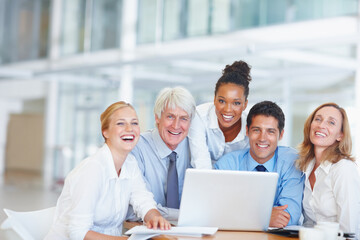 Happy executives using laptop. Portrait of happy business people working together on laptop.