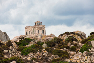l'ancien semaphore  de Capo Testa en Sardaigne qui servait de phare au milieu des roches de granit sous un ciel d'orage