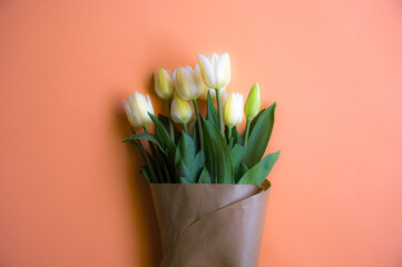 Flatlay of tulips on the orange paper background.