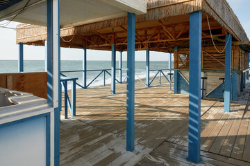 Naklejka na ściany i meble Empty wooden terrace. Blue sea view. Bar terrace by the sea.