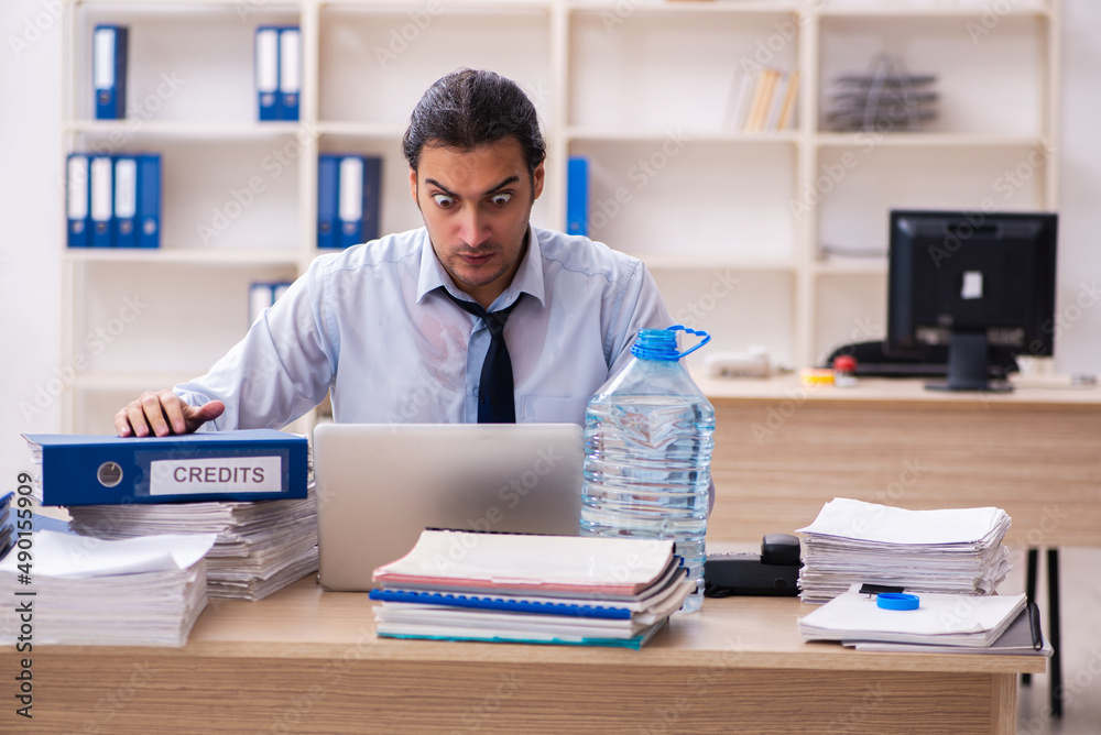 Wall mural young male employee sweating at workplace