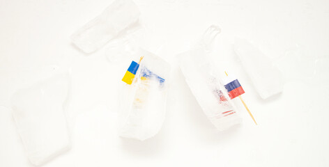The split of two friendly countries. Two flags frozen in ice flags of Russia and Ukraine on a white background.