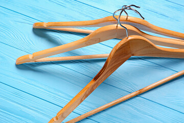 Clothes hangers on color wooden background