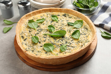 Delicious homemade spinach pie on light grey table