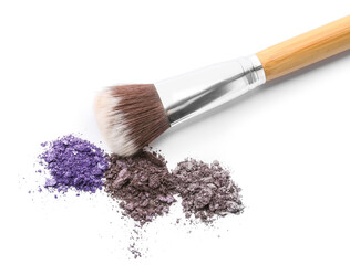 Makeup brush and loose eyeshadows on white background
