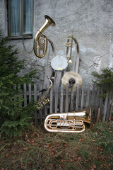 Musical instruments including tuba, trumpet, saxophone and drum on an old wall