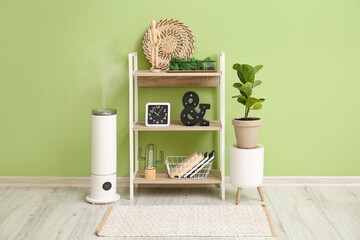 Book shelf with decor and humidifier near color wall
