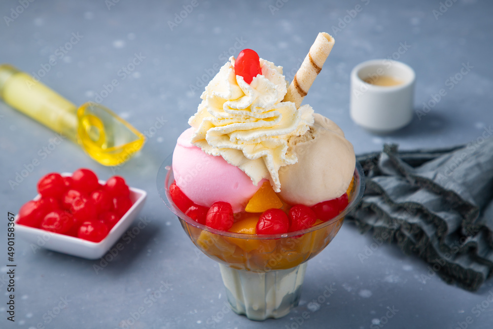 Sticker tasty ice cream with fruits and whipped cream on a gray table