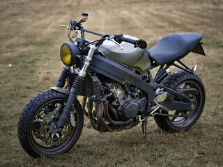 Closeup shot of a motorcycle in the field © Djaccomo/Wirestock