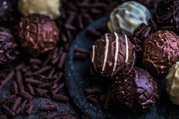 chocolate truffles on a small slate against dark background