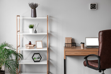 Interior of stylish office with modern workplace and shelving unit