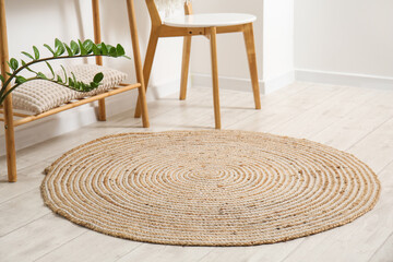 Wicker rug on light wooden floor in room