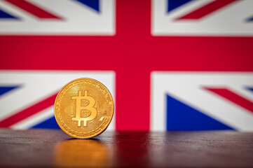 Bitcoin physical golden coin with British flag in the background