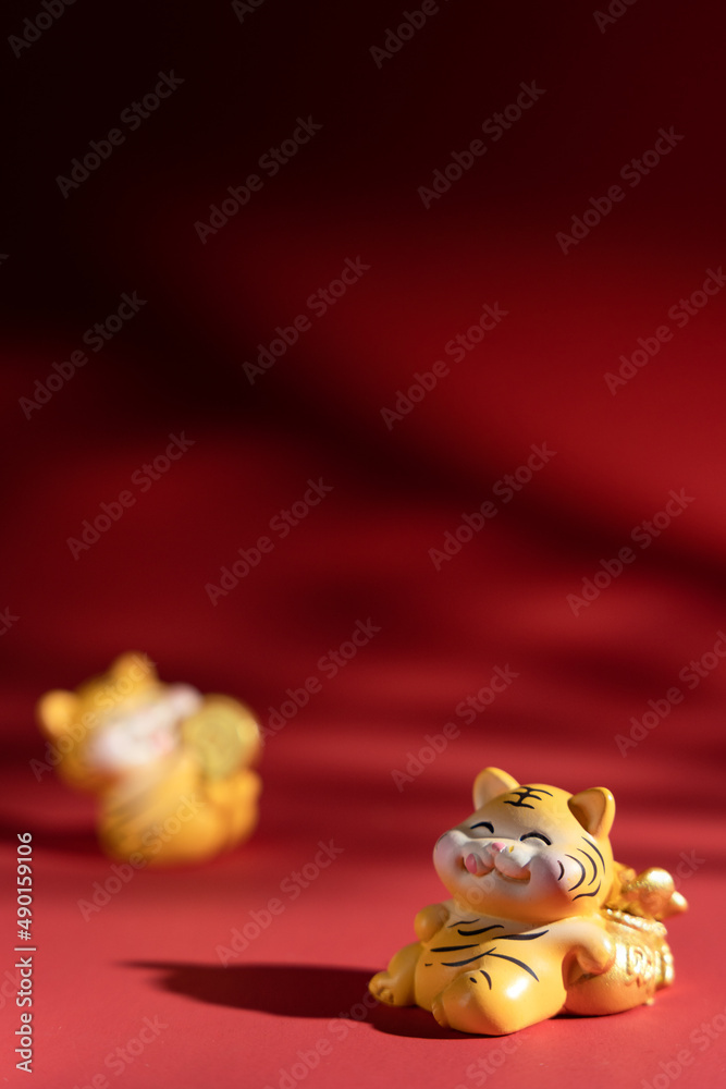 Wall mural vertical shot of cute tiger figurines isolated on red background