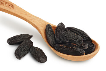 Tonka bean in wooden spoon isolated on white background with clipping path and full depth of field. Bean of Dipteryx odorata