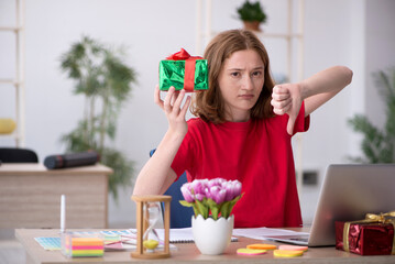 Obraz na płótnie Canvas Young female designer celebrating Christmas in the office