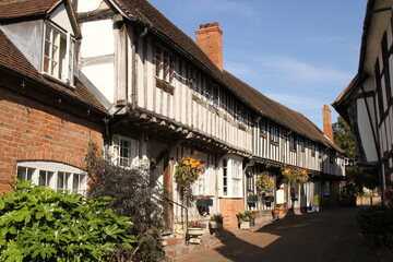 Half timbered, black & white houses, with hanging baskets & floral blooms during summertime  in Shakespeare country. Malt Mill Lane, Alcester, Warwick
