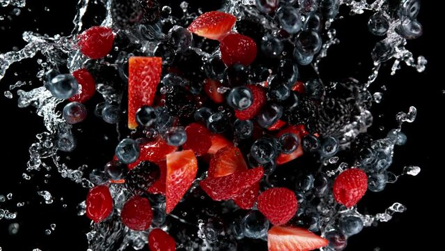 Super slow motion of rotating berries fruit with splashing water, black background. Filmed on high speed cinema camera, 1000 fps.